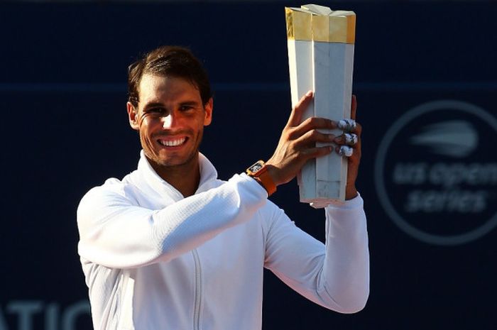 Petenis tunggal putra Spanyol, Rafael Nadal, mengangkat trofi yang diraih setelah menjuarai turnamen Rogers Cup 2018 di Toronto, Kanada, Minggu (12/8/2018).