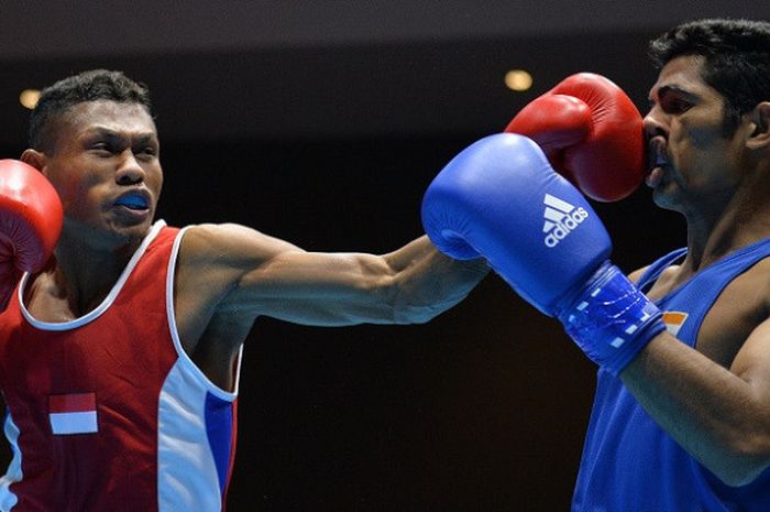 Petinju Indonesia Libertus Gha (kiri) melepaskan pukulan ke arah petinju India Ashish (kanan) saat laga babak semifinal kelas Men's Light Welter (64 Kg) pada 18th Asian Games Invitation Tournament di JIExpo, Kemayoran, Jakarta, Rabu (14/2/2018). 