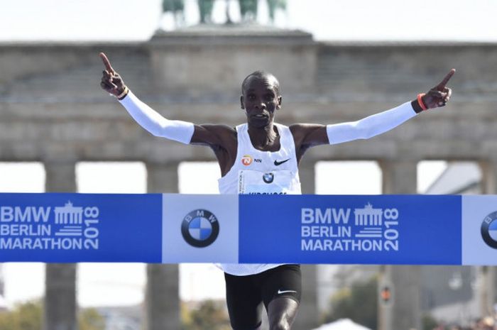 Pelari asal Kenya, Eliud Kipchoge, melewati garis finish di Berlin Marathon untuk mencatatkan rekor lari marathon dunia pada Minggu (16/9/2018).