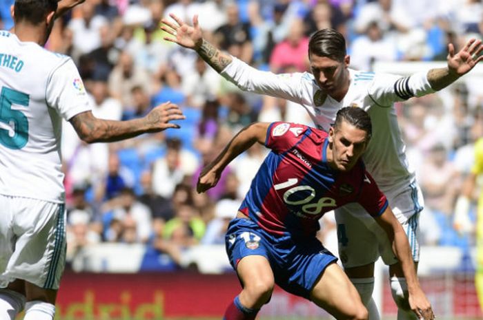 Kapten Real Madrid, Sergio Ramos, berjibaku dengan pemain Levante dalam laga di Santiago Bernabeu, Sabtu (9/9/2017)