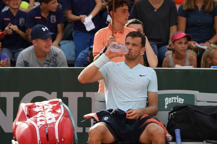 Petenis tunggal putra asal Bulgaria, Grigor Dimitrov, beristirahat saat menjalani pertandingan melawan Jared Donaldson (Amerika Serikat) pada babak kedua French Open 2018 di Roland Garros, Paris, Prancis, Rabu (30/5/2018).