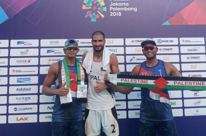 Pasangan pebola voli pantai putra Indonesia, Gilang Ramadhan/Danangsyah Yudistira Pribadi (kiri), berpose dengan salah satu wakil pemain Palestina di Jakabaring Sport City Palembang, Selasa (21/8/2018).