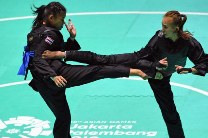  Pesilat Indonesia Wewey Wita (kanan) bertanding melawan pesilat Thailand Suda Lueangaphichatkun (kiri) dalam babak perempat final Kelas B Putri Asian Games 2018 di Padepokan Pencak Silat Taman Mini Indonesia Indah (TMII), Jakarta, Jumat (24/8).  