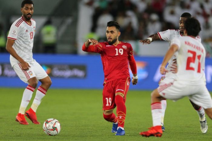 Gelandang timnas Bahrain, Kamil Al-Aswad di antara tiga pemain timnas UEA pada laga pertama Grup A Piala Asia 2019 di Stadion Zayed Sport City, 5 Januari 2019. 