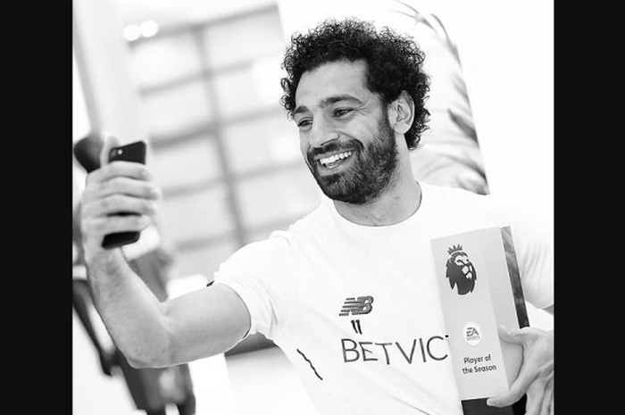   Pemain sayap Liverpool, Mohamed Salah terlihat sedang selfie bersama trofi yang baru saja diraihnya.  