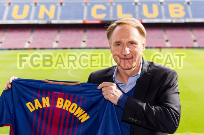 Novelis Kondang, Dan Brown memamerkan jersey Barcelona bertuliskan namanya saat berkunjung ke Camp Nou pada, Jumat (20/10/2017).