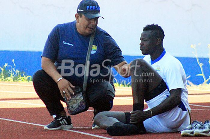 Dokter tim Persib, Rafi Ghani berbicang-bincang dengan Ezechiel N'Douassel seusai latihan di Stadion Sport Jabar Arcamanik, Kota Bandung, Selasa (4/9/2018).