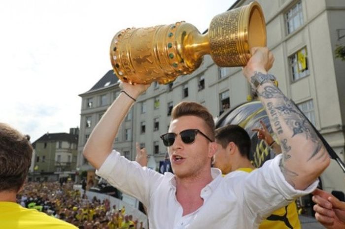 Gelandang Borussia Dortmund, Marco Reus, mengangkat trofi DFB Pokal dalam parade yang digelar di Borsigplatz, Dortmund, pada 28 Mei 2017.