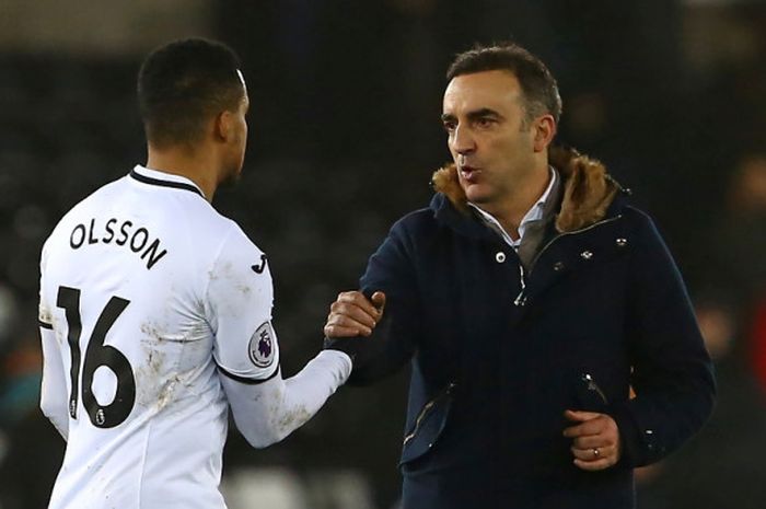 Manajer Swansea City, Carlos Carvalhal (kanan), bersalaman dengan bek timnya, Martin Olsson, seusai laga Liga Inggris kontra Tottenham Hotspur di Stadion Liberty, Swansea, pada 2 Januari 2018.