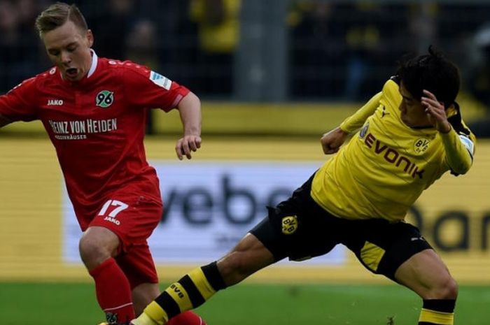 Uffe Bech (kiri) berduel dengan Shinji Kagawa dalam partai Liga Jerman antara Borussia Dortmund lawan Hannover, 13 Februari 2016.