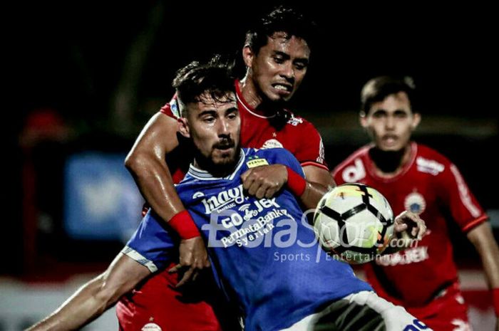      Maman Abdurrahman menjaga ketat Jonathan Bauman pada laga Persija Jakarta melawan Persib Bandung di Stadion PTIK, Jakarta, Sabtu (30/6/2018).     