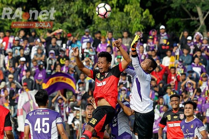 Gelandang Mojokerto Putra, Djayusman Triadi (26), berduel di udara dengan kiper Persik Kediri, Teddy Heri Setiawan, dalam laga lanjutan Liga 2 di stadion Gelora Gajahmada Mojosari, Jawa Timur (06/05/2017) Sabtu sore.