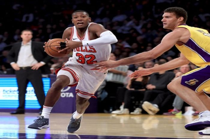 Pemain Bulls, Kris Dunn (putih #32), saat berusaha melewati pemain Lakers, Brook Lopez (kuning #11), pada laga lanjutan NBA 2017/18 yang berlangsung Selasa (21/11/2017) waktu Amerika Serikat.