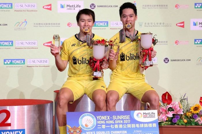 Pasangan ganda putra Indonesia, Marcus Fernaldi Gideon/Kevin Sanjaya Sukamuljo, berpose dengan medali dan trofi Hong Kong Open 2017 di Hong Kong Coliseum, Minggu (26/11/2017)