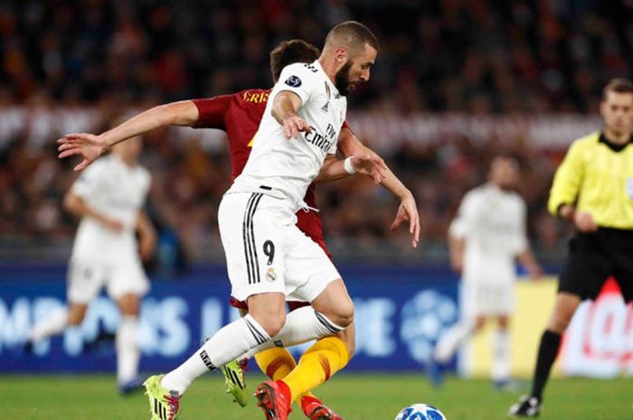 Striker Real Madrid, Karim Benzema, berduel dengan gelandang AS Roma, Bryan Cristante, dalam laga Liga Champions di Stadion Olimpico, Roma, pada Rabu (28/11/2018) dini hari WIB.