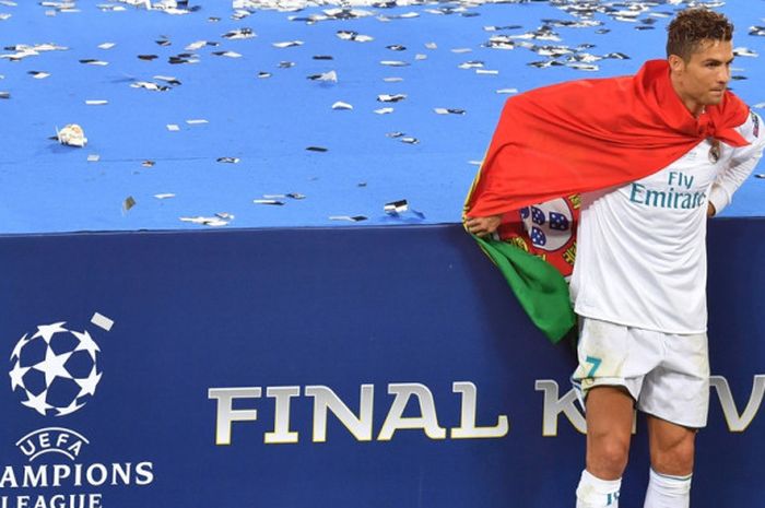 Megabintang Real Madrid, Cristiano Ronaldo, melakukan selebrasi dengan memegang bendera Portugal seusai laga final Liga Champions kontra Liverpool FC di Stadion NSC Olimpiyskiy, Kiev, Ukraina pada 26 Mei 2018.