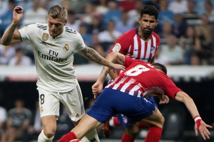 Gelandang Real Madrid, Toni Kroos, berduel dengan pemain Atletico Madrid, Saul Niguez, dalam pertandingan Liga Spanyol di Stadion Santiago Bernabeu, 29 September 2018.