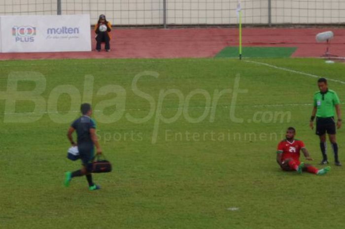 Seorang staf medis timnas Indonesia mendekati Marinus Wanewar yang mengalami nyeri setelah salah kuda-kuda dalam menembak pada laga versus Myanmar, Selasa (29/8/2017). 