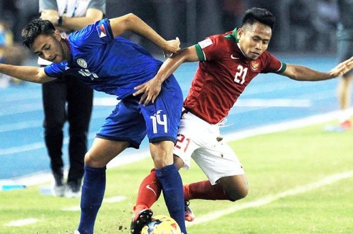 Gelandang timnas Indonesia, Andik Vermansah (kanan), berebut bola dengan gelandang timnas Singapura, Hariss Harun,  dalam laga Piala AFF 2016 di Philippine Sports Stadium, Bocaue, Selasa (22/11/2016).