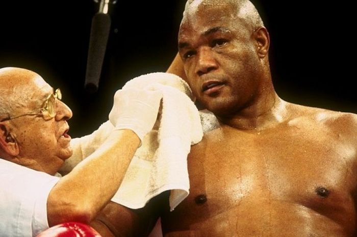 George Foreman (kanan), mendapat perawatan dari timnya dalam pertandingan terakhirnya di dunia tinju profesional menghadapi Shannon Briggs di Mark Etess Arena, Taj Mahal hotel, New Jersey, Amerika Serikat pada 22 November 1997.