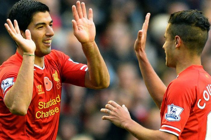 Penyerang Liverpool, Luis Suarez dan Philippe Coutinho, merayakan gol Suarez ke gawang Fulham pada laga Liga Inggris di Stadion Anfield, Liverpool, pada 9 September 2013.