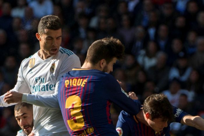 Megabintang Real Madrid, Cristiano Ronaldo (kiri), berduel dengan bek FC Barcelona, Gerard Pique, dalam laga Liga Spanyol di Stadion Santiago Bernabeu, Madrid, pada 23 Desember 2017.