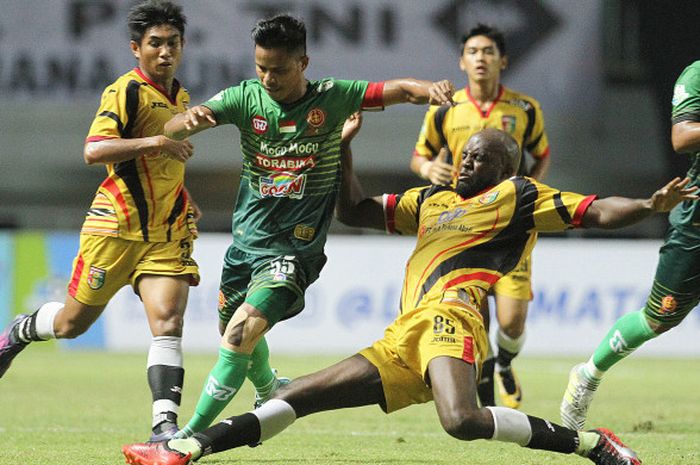  Marquee player Mitra Kukar, Mohamed Sissoko, melancarkan sliding tackel ke pemain PS TNI, Manahati 