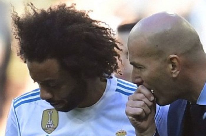 Bek kiri Real Madrid, Marcelo (kiri), sedang mendengarkan arahan dari pelatihnya, Zinedine Zidane, pada laga pekan ke-17 La Liga Spanyol melawan FC Barcelona, di Stadion Santiago Bernabeu, Sabtu (23/12/2017). 