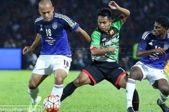 Andik Vermansah diapit dua pemain Johor DT, Mahali Jasuli (18), dan Shakir Shaari, di Stadion Larkin, Johor Bahru, Sabtu (13/2/2016).