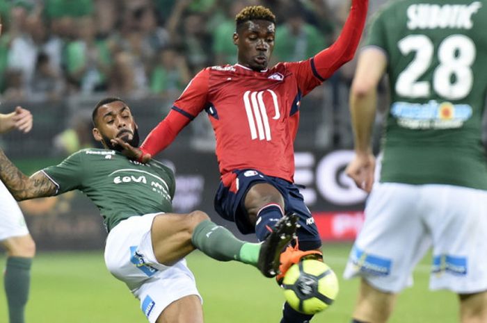 Pemain Saint-Etienne, Yann M'Vila (tengah), berduel dengan gelandang Lille, Yves Bissouma (kanan), dalam pertandingan Liga Prancis 2017-2018 di Stadion Geoffroy Guichard, Saint-Etienne, Prancis, pada 19 Mei 2018.