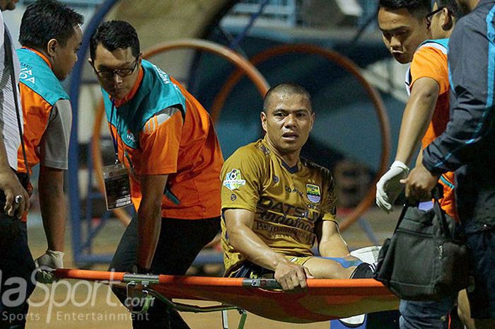 Striker Persib Bandung, Tantan, ditandu keluar lapangan seusai mengalami cedera saat tampil melawan Arema FC dalam laga pekan ke-19 Liga 1 di Stadion Kanjuruhan Malang, Jawa Timur, Sabtu (12/08/2017) malam.