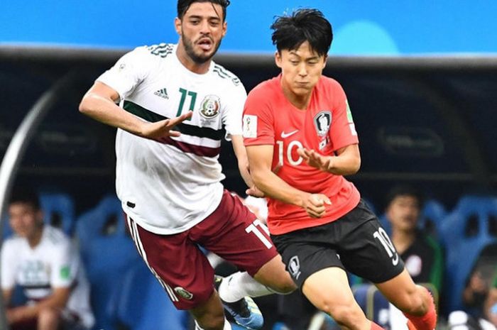 Penyerang Meksiko, Carlos Vela (kiri) beradu dengan gelandang Korea Selatan, Lee Seung-Woo (kanan) dalam laga penyisihan Grup F Piala Dunia 2018, Sabtu (23/6/2018).