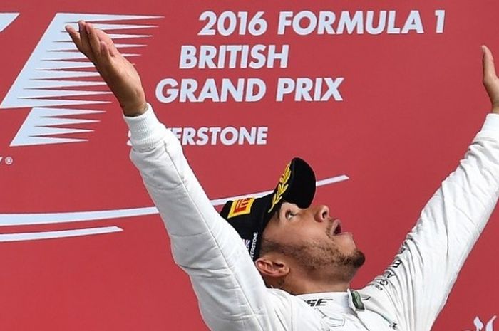 Pebalap Mercedes, Lewis Hamilton, bereaksi di podium setelah memenangi GP Inggris di Sirkuit Silverstone, Minggu (10/7/2016).