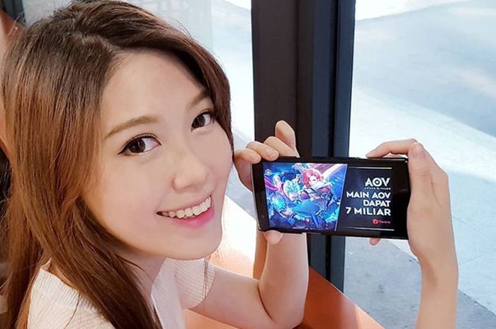 MC sekaligus pembaca acara televisi, Jeanice Ang, berfoto sembari memainkan game Arena of Valor (AOV)