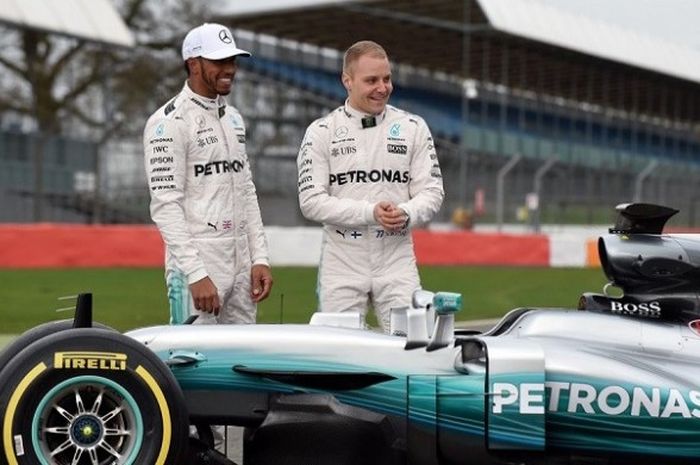 Pebalap Mercedes, Lewis Hamilton (Inggris Raya/kiri) dan Valtteri Bottas (Finlandia) berpose saat memperkenalkan mobil Mercedes W08 Hybrid melalui pada acara peluncuran yang digelar di Sirkuit Silverstone, Inggris, Kamis (23/2/2017) malam waktu setempat.