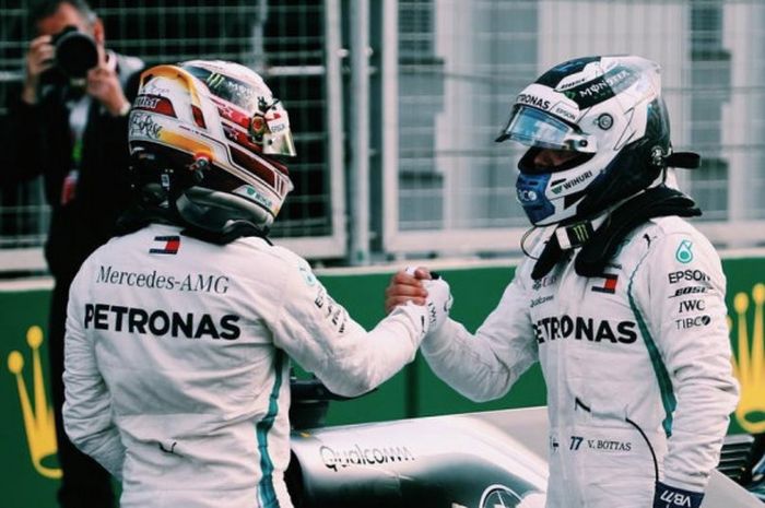 Pebalap Mercedes, Lewis Hamilton (kiri), berjabat tangan dengan rekan setimnya, Valtteri Bottas, setelah kualifikasi GP Azerbaijan di Sirkuit Baku City, Azerbaijan (28/4/2018). 