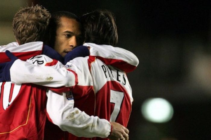 Striker Arsenal, Thierry Henry (tengah), memeluk rekan setimnya Dennis Bergkamp (kiri) dan Robert Pires (kanan) usai menundukkan Crystal Palace 5-1 pada 14 Februari 2005.