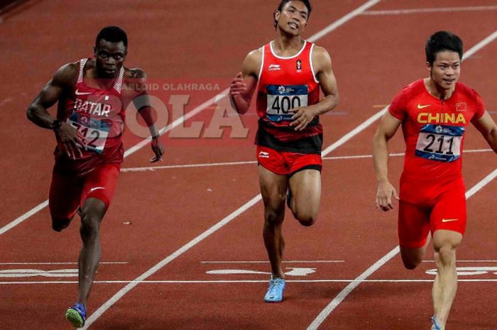 Sprinter asal Indonesia, Lalu Muhammad Zohri (tengah), berduel dengan Tosin Ogunode (kiri) dan Su Bingtian (kanan) pada final nomor lari 100 meter putra cabang atletik Asian Games 2018 di Stadion Utama Gelora Bung Karno, Jakarta, Minggu (26/8/2018).