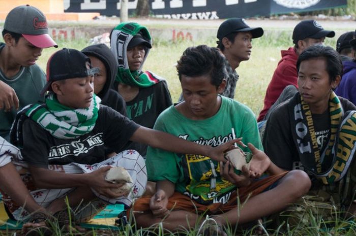 Para Bonek mendistribusikan nasi bungkus sebagai bentuk kepedulian Manajemen Persebaya Surabaya.