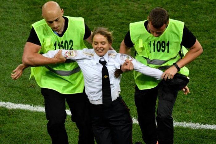 Petugas mengamankan penyusup yang masuk ke lapangan dalam laga final Piala Dunia 2018 Prancis vs Kroasia di Stadion Luzhniki, Moskow, 15 Juli 2018.