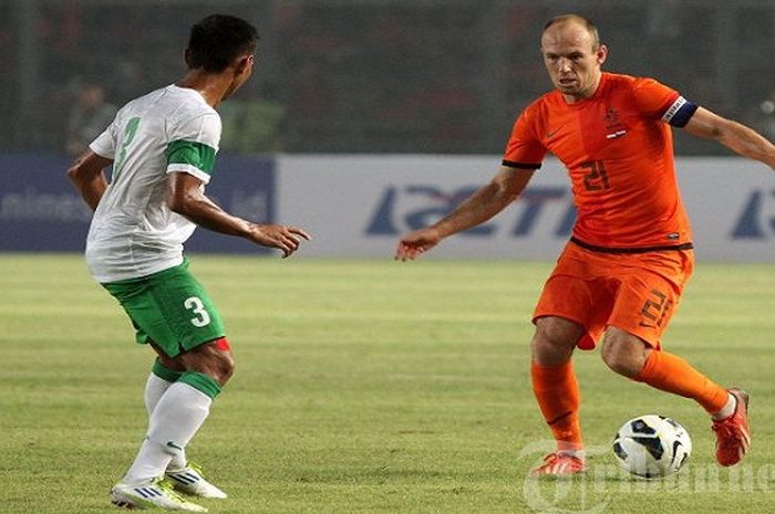 Pemain Tim Nasional Belanda, Arjen Robben (kanan) mencoba melewati adangan pemain belakang Timnas Indonesia, Zulkifli Syukur dalam pertandingan yang digelar di Stadion Utama Gelora Bung Karno (SUGBK), Senayan, Jakarta, Jumat (7/6/2013). Timnas Indonesia akhirnya takluk 0-3 dari Timnas Belanda lewat 2 gol dari Siem de Jong dan Arjen Robben. 