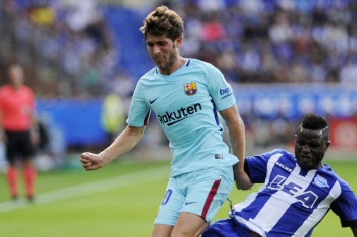 Pemain FC Barcelona, Sergi Roberto (kiri) berduel dengan pemain Deportivo Alaves, Wakaso Mubarak, dalam laga kedua tim pada Sabtu (26/8/2017).