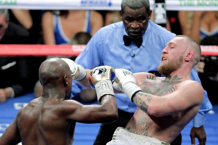 Wasit Robert Byrd (tengah) memimpin jalannya duel tinju antara Floyd Mayweather Jr. (kiri) dan Conor McGregor di T-Mobile Arena, Las Vegas, Nevada, Amerika Serikat, Sabtu (26/8/2017).