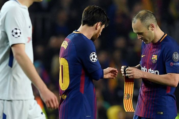 Gelandang FC Barcelona, Andres Iniesta (kanan), memberikan ban kapten kepada Lionel Messi dalam laga leg kedua babak 16 besar Liga Champions kontra Chelsea di Stadion Camp Nou, Barcelona, Spanyol, pada 14 Maret 2018.