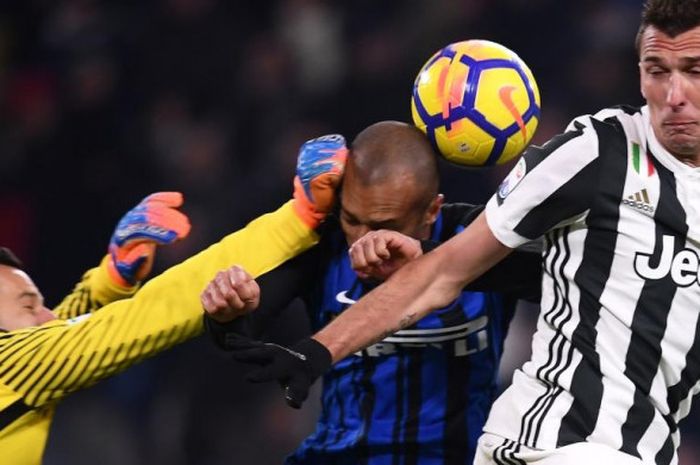 Kiper Inter Milan Samir Handanovic (kiri) berupaya meninju bola sundulan striker Juventus Mario Mandzukic (kanan) dalam partai Liga Italia di Stadion Allianz Turin, 9 Desember 2017.