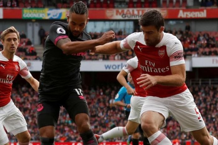 Theo Walcott (tengah) berusaha melewati Sokratis Papastathopoulos dalam laga Liga Inggris antara Arsenal versus Everton di Stadion Emirates London, 23 September 2018.