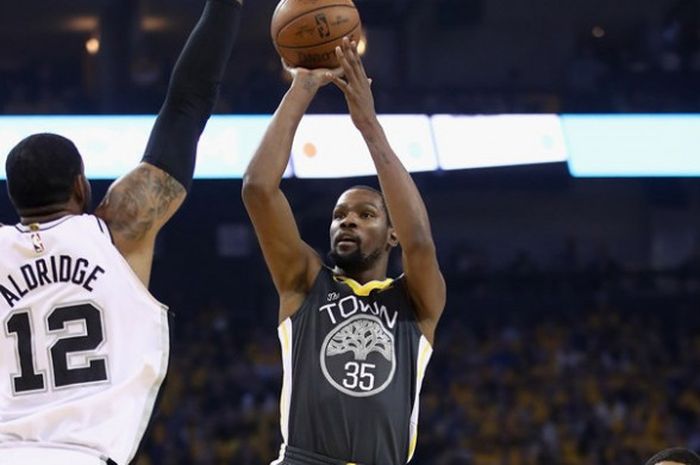 Pemain bintang Golden State Warriors, Kevin Durant, melepas tembakan seraya dijaga pebasket San Antonio Spurs, LaMarcus Aldridge, pada laga gim kedua babak kesatu play-off Wilayah Barat NBA 2018 di Oracle Arena, Oakland, California, Amerika Serikat, Senin (16/4/2018). Warriors menang 116-101.