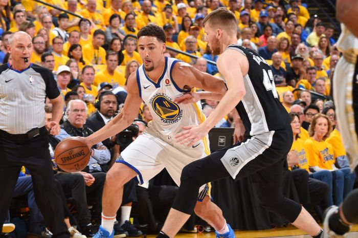 Pemain Golden State Warriors, Klay Thompson sedang mencoba untuk melewati pemain San Antonio Spurs pada ajang NBA 'Play-off' 2018, Minggu (15/4/2018).