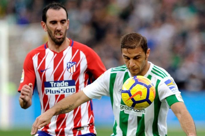 Gelandang Real Betis, Joaquin Sanchez (kanan), berduel dengan bek Atletico Madrid, Diego Godin, dalam laga Liga Spanyol di Stadion Benito Villamarin, Sevilla, pada 10 Desember 2017.