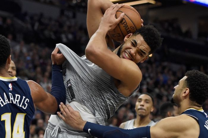 Center Minnesota Timberwolves, Karl Anthony-Towns (jersey abu-abu), dikawal dua pemain Denver Nuggets pada laga terakhir musim reguler NBA 2017-2018 yang berlangsung di Target Center, Minneapolis, Minnesota, Amerika Serikat (AS), Rabu (11/4/2018) malam waktu setempat.